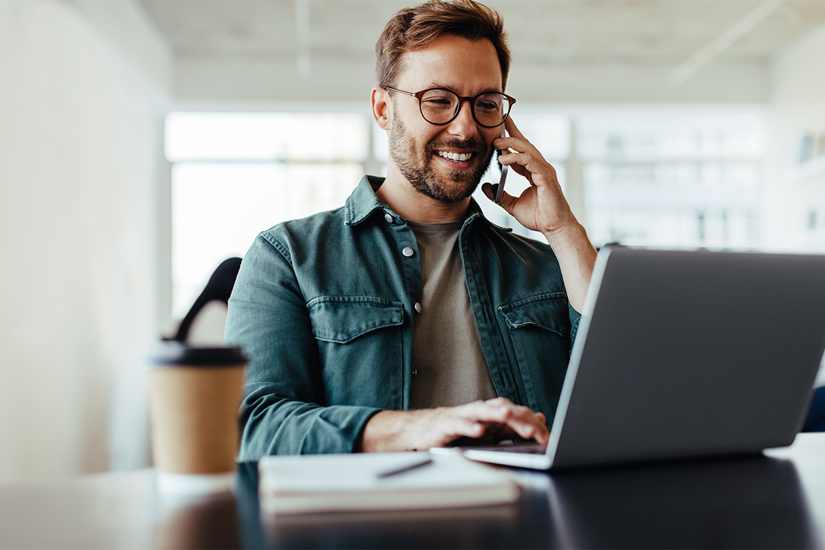 Mann telefoniert am Laptop – Smart Upgrade berät euch zur Arbeitssicherheit und Gefährdungsbeurteilung
